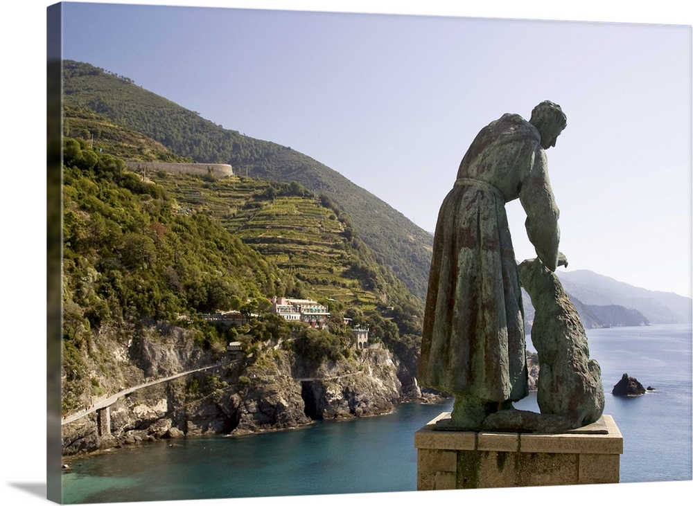 Europe, Italy, Cinque Terre, Monterosso. A statue of St. Francis of Assisi petting a dog and looking out over the sea.