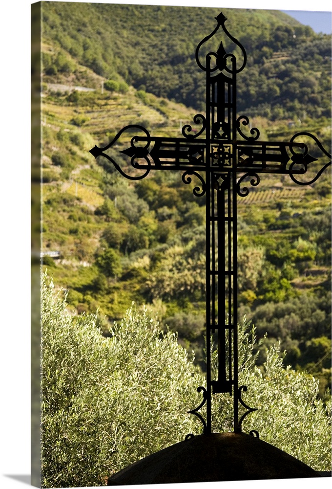 Europe, Italy, Cinque Terre, Monterosso. An iron cross outside the Church of the Cappuccin Monks with green terraced hills...