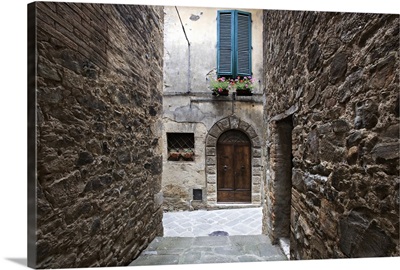 Italy, Petroio, Narrow walkway frame a doorway in a Tuscany village