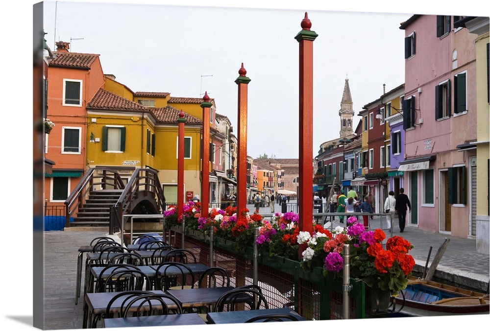 Italy, Venice, Burano. Cafe tables along the canal.