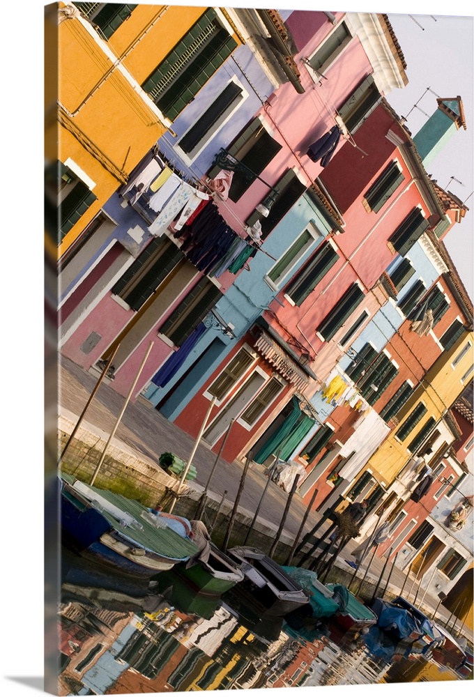 Italy, Venice, Burano. A tilted view of colorful houses and their reflections on a canal.