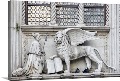 Italy, Venice. Statue of a winged lion and the Doge on the Doge's Palace