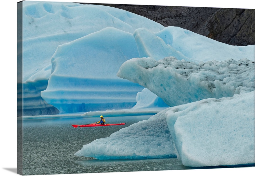 Kayaker exploring Grey Lake amid icebergs, Torres del Paine National Park, Chile, South America, Patagonia.