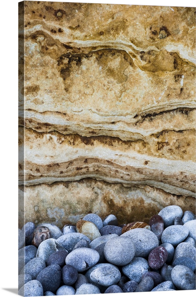 North America, USA, Michigan, Pictured Rock National Lakeshore.  Weathered beach rocks against sandstone rock formation al...