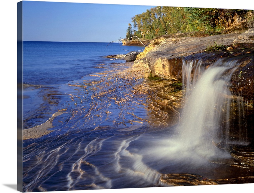 USA, Michigan, Pictured Rocks National Lakeshore, Small waterfall courses across sandstone shoreline at Miners Beach befor...
