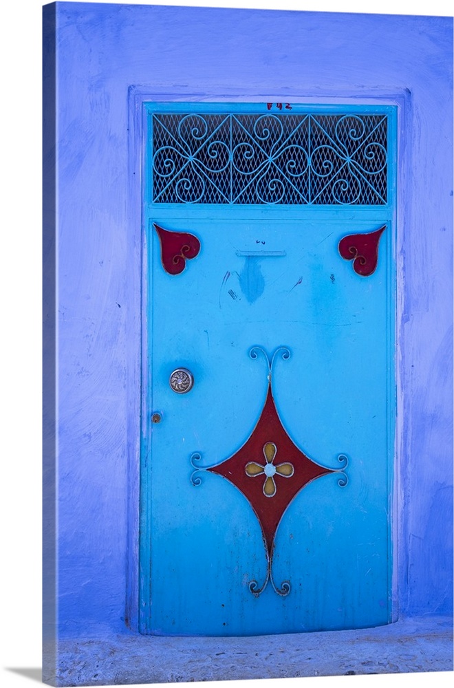 Morocco, Chefchaouen. A traditional metal painted door with red heart-like motifs.