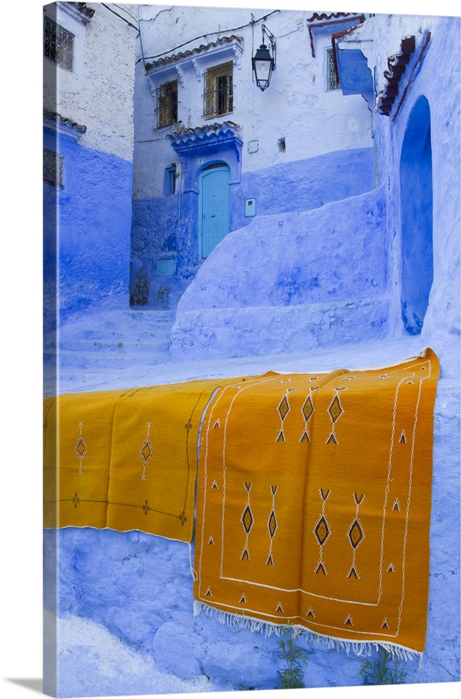 Africa, Morocco, Chefchaouen. Rugs draped on a wall in the blue town.