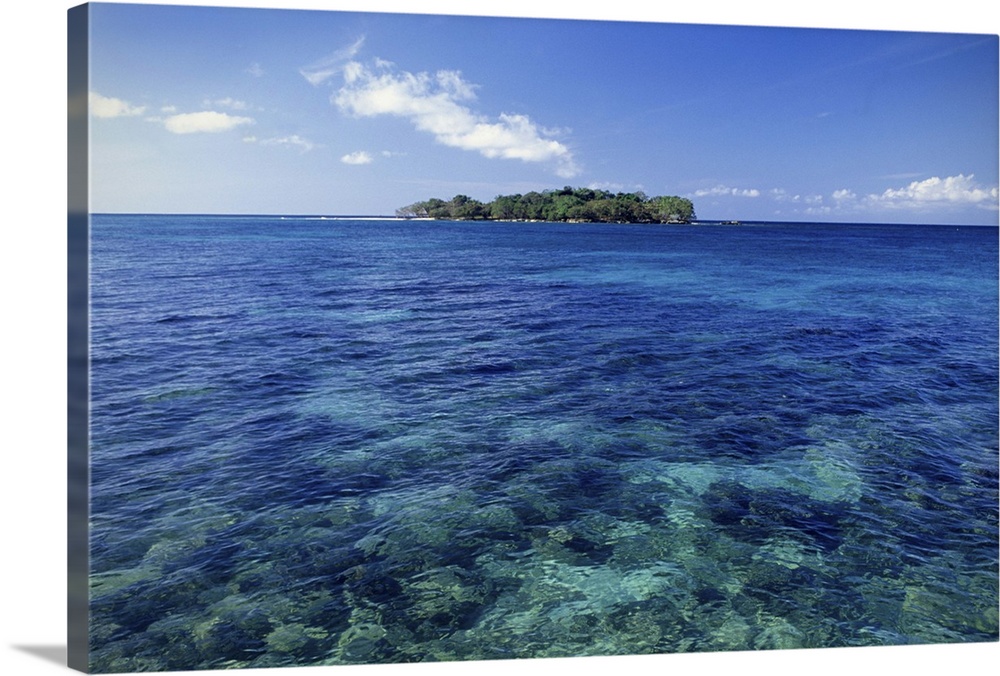 Negril, Jamaica. The island of Booby Cay at the end of Long Bay Beach. Tropical island with clear green water, rocks visible.