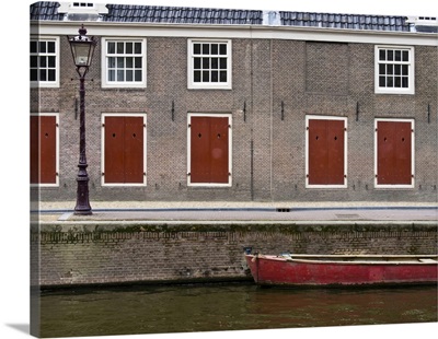 Netherlands, Amsterdam, Colorful Red Doors Along The Canal With A Red Boat
