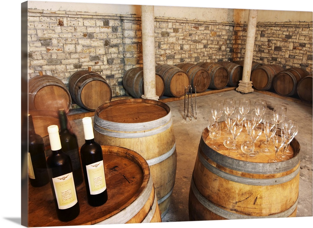 Oak barrels and bottles and glasses set up for a tasting. Cobo winery, Poshnje, Berat. Albania, Balkan, Europe.