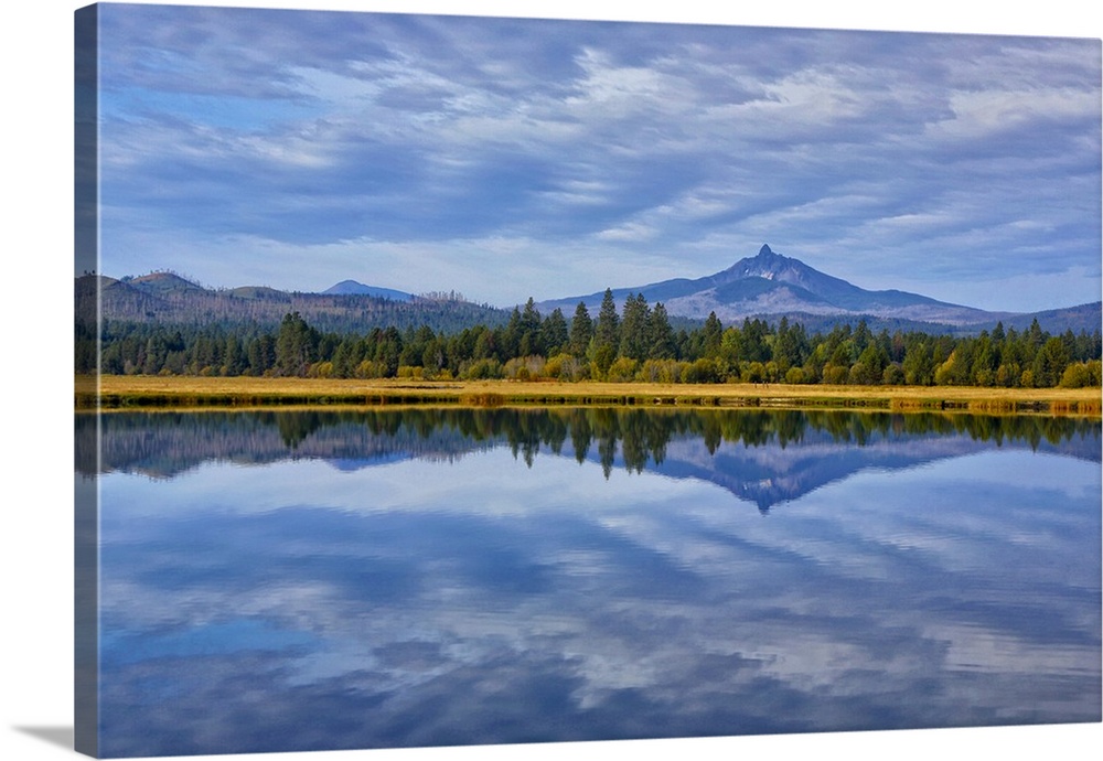 USA, Oregon. Clouds reflect in small lake at Black Butte Ranch.