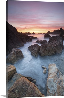 Oregon. Sunset and incoming tide at Harris Beach State Park. Rocks at arch