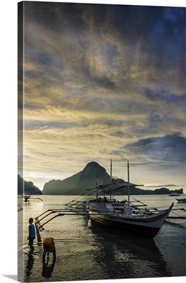 Outrigger at sunset in the bay of El Nido, Bacuit Archipelago, Palawan, Philippines