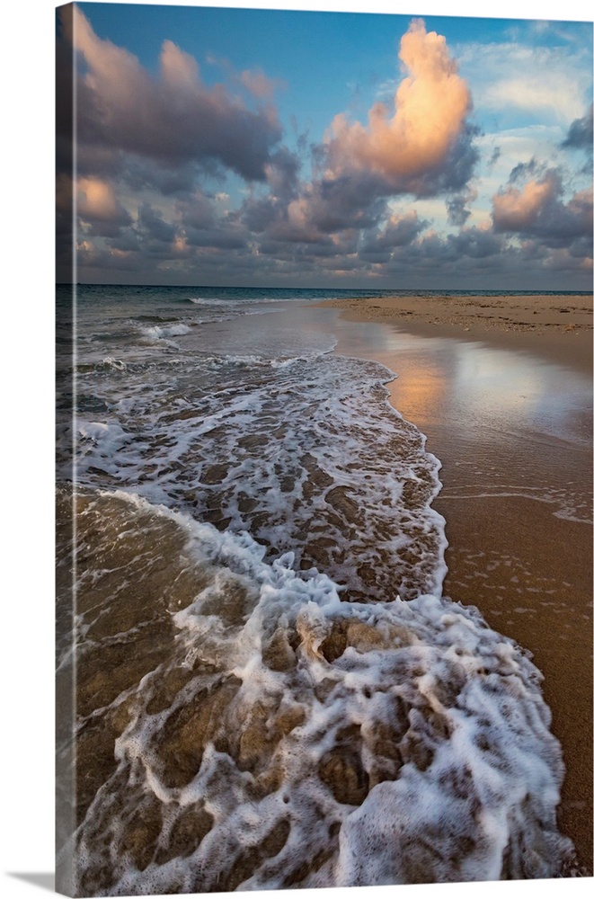 Pacific Islands, Kingdom of Tonga. Remote sandy beach on an uninhabitated island with incoming tide, clouds and reflection...