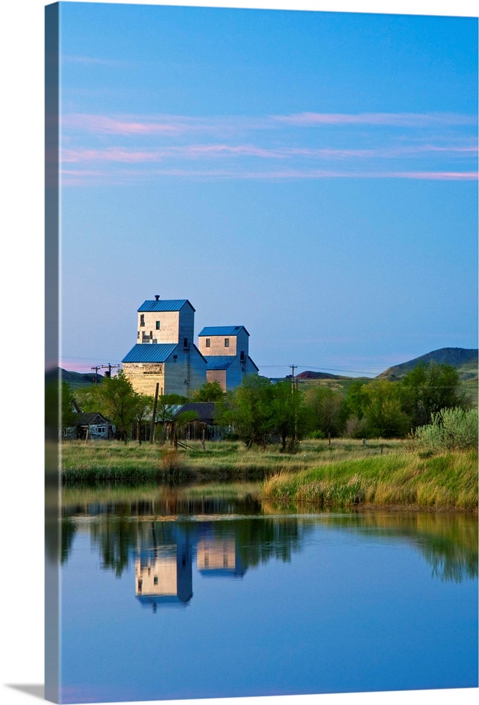 Pair of grain elevators reflect into pond at Sentinel Butte North Dakota