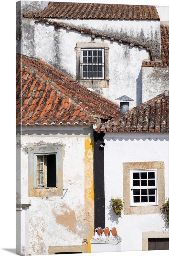 Portugal, Obidos. Ancient, red, terra cotta tiled roof tops, lines. Old windows.