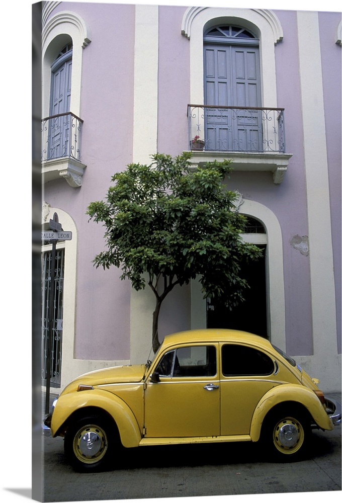 Puerto Rico, Ponce, Historic District. 19th century pink and white house with yellow VW Beetle parked in front.