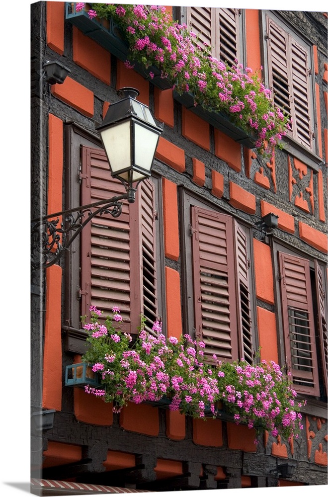 Red building with shuttered windows and flower boxes in the village of Ribeauville, Eastern France...france, french, europ...