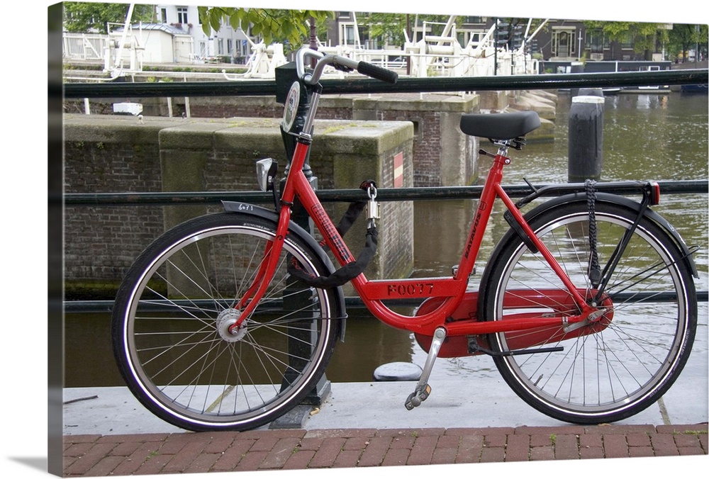 Rental bicycle parked along the Amstel River in Amsterdam, Netherlands.