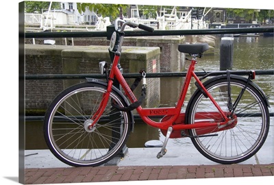 Rental bicycle parked along the Amstel River in Amsterdam, Netherlands
