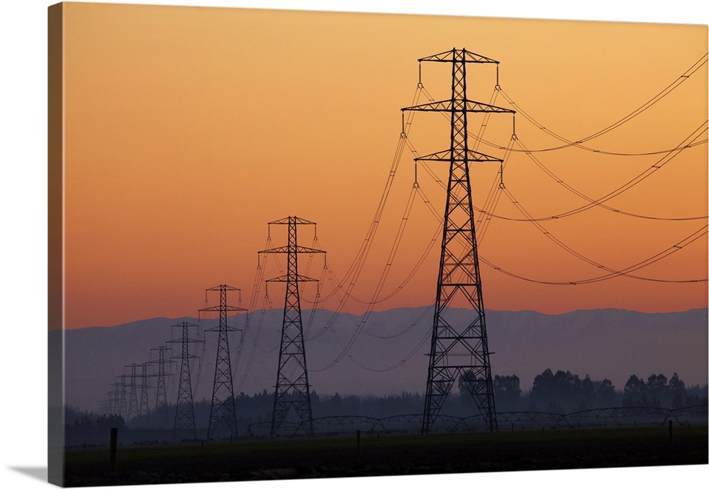 Row of power pylons at sunset, Mid Canterbury, South Island, New Zealand.