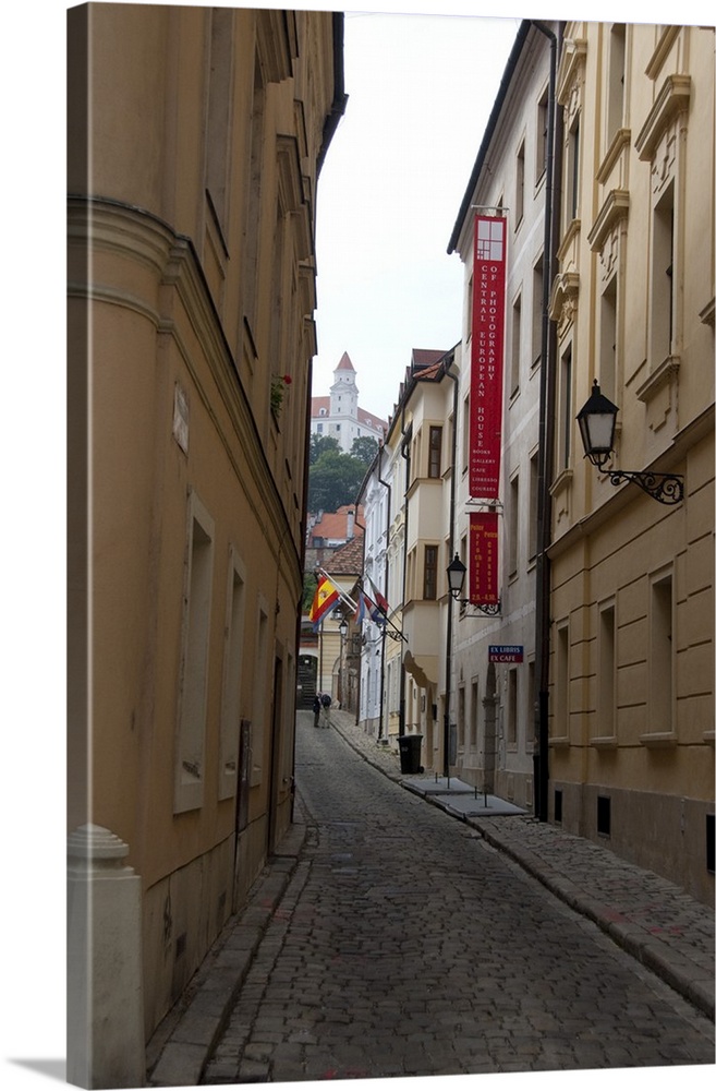 Slovakia, Bratislava. Narrow street in historic district with view of Bratislava Castle in distance.