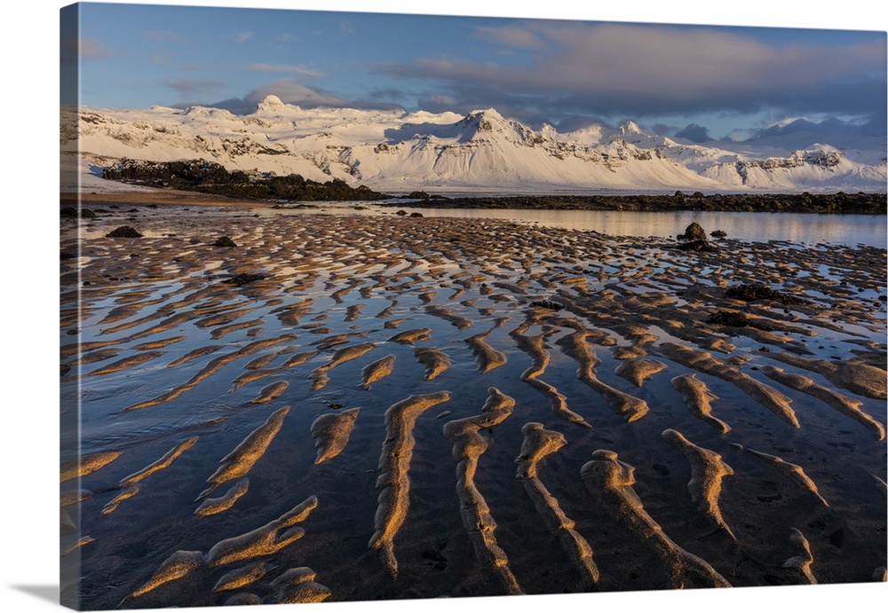 Snow capped mountain above the North Atlanic shoreline on the Snaefellsnes peninsula in western Iceland.