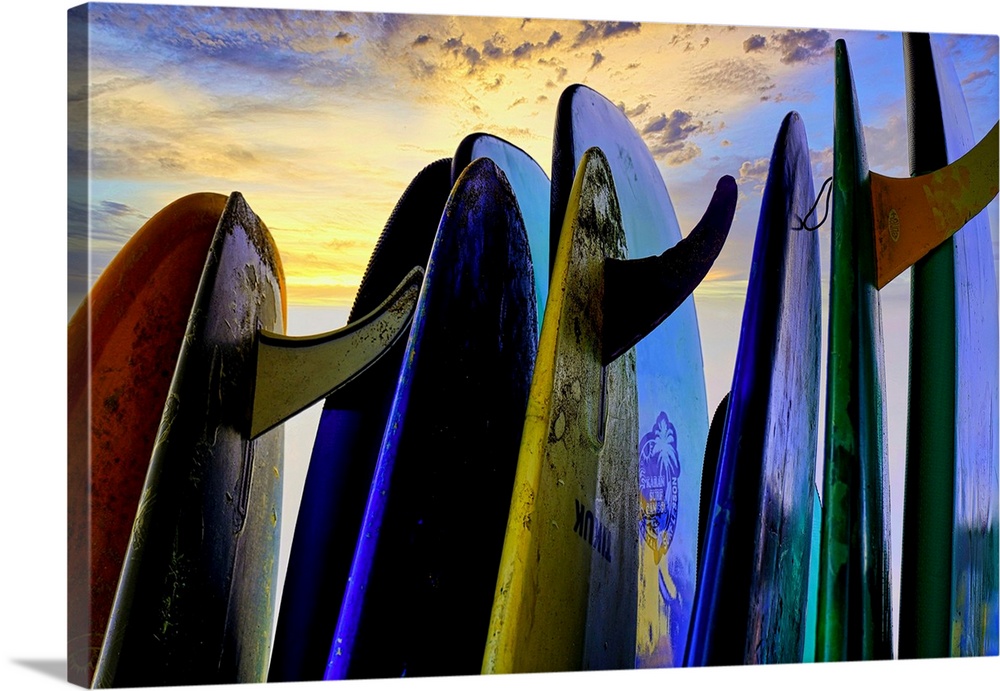 Stacked surf boards at sunset after a day of surf school in Canggu, Bali, Indonesia.