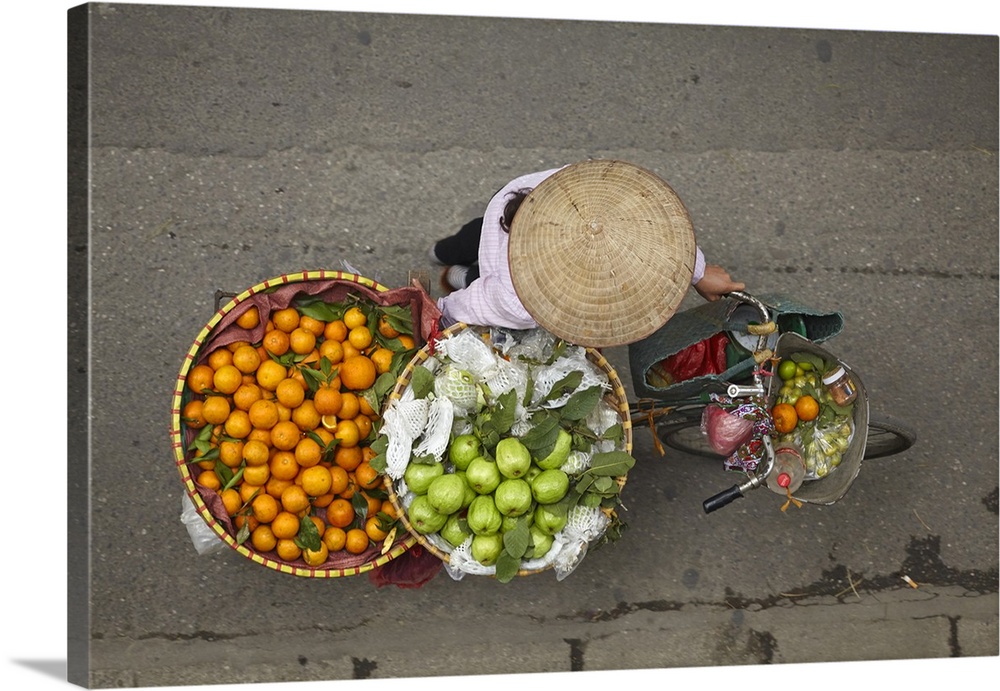 Street vendor with round baskets of fruit on bicycle, Old Quarter, Hanoi, Vietnam