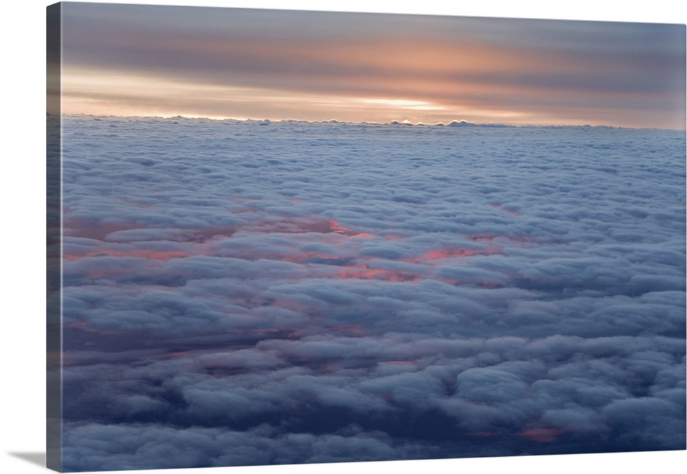 Sunrise from an airliner looking down at clouds. Credit: Dennis Flaherty