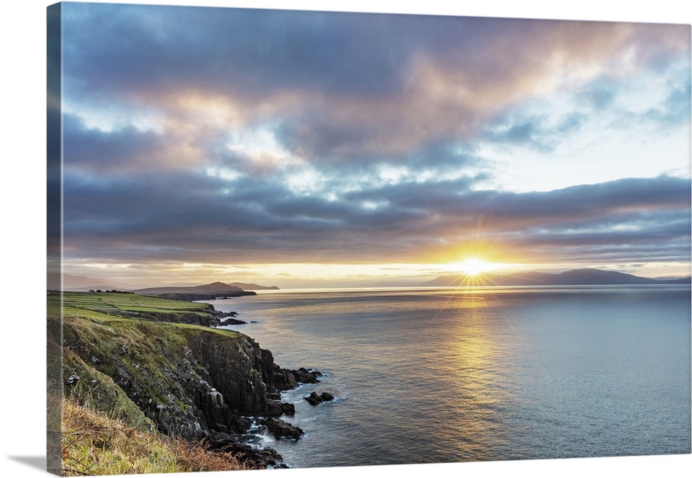 Sunrise over Dingle Bay as fishing boats heads out in County Kerry, Dingle, Ireland