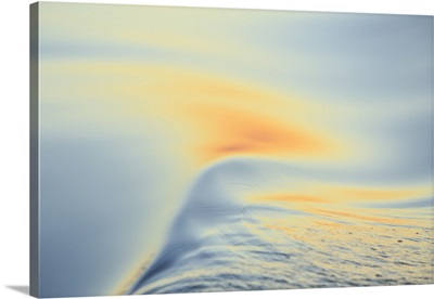 Sunset colors and patterns on small waves in water.