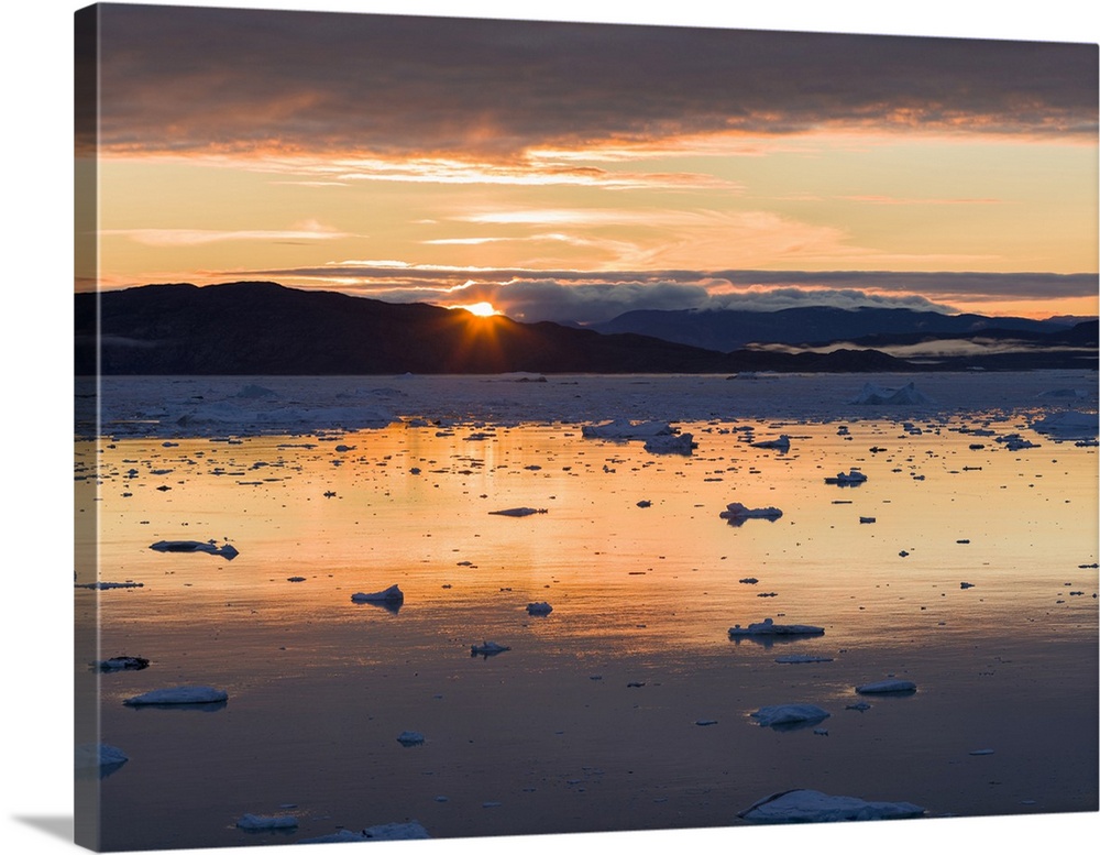Sunset over fjord with icebergs close to Eqip Glacier in Greenland, Danish Territory.