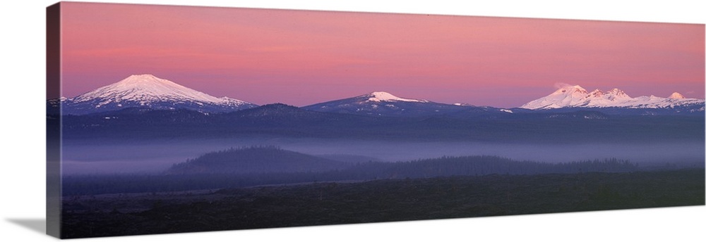USA, Oregon, Cascades Range. The pink blanket of sunrise warms the Oregon Cascades, as seen from Lava Butte.
