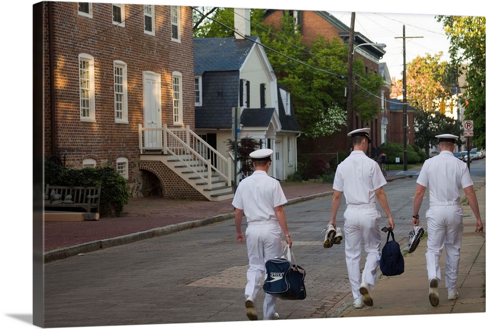 Three male U.S. Navy cadets walk down street with historic homes (viewed from behind), Annapolis, Maryland, United States.