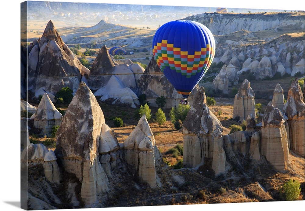 Turkey,Anatolia,Cappadocia, Goreme. Hot air balloon flying above/among rock formations and field landscapes in the Red Val...