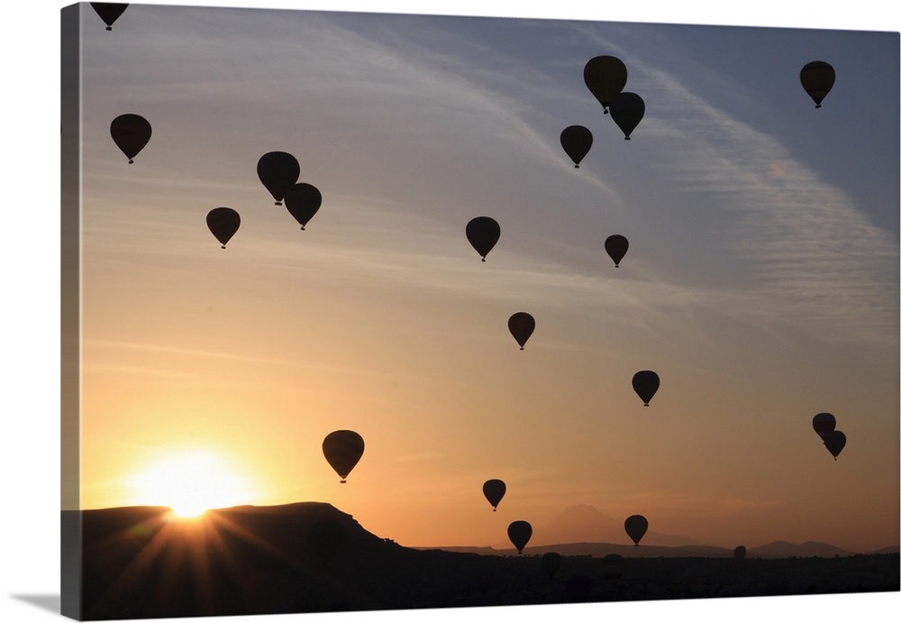 Turkey,Anatolia,Cappadocia, Goreme. Hot air balloons flying above/among rock formations and field landscapes in the Goreme...