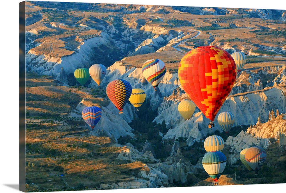 Turkey,Anatolia,Cappadocia, Goreme. Hot air balloons flying above/among rock formations and field landscapes in the Red Va...
