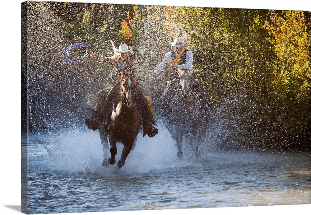 USA, Wyoming, Shell, The Hideout Ranch, Cowboy and Cowgirl on Horseback Running through the River (MR/PR)