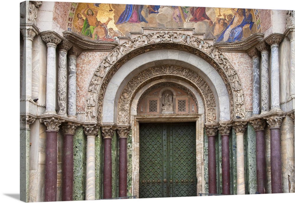 Venice, Veneto, Italy - Carvings and columns line the entrance to an arched church door. Horizontal shot.