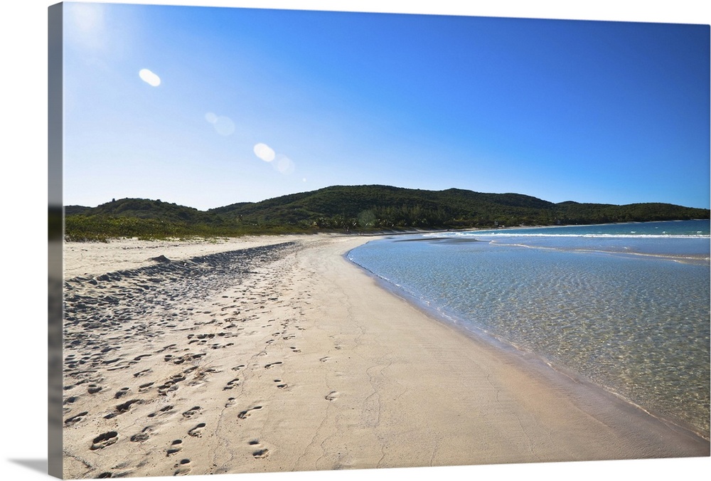Vieques, Puerto Rico - Gentle waves are rolling up onto the white sands of a tropical beach. Horizontal shot.