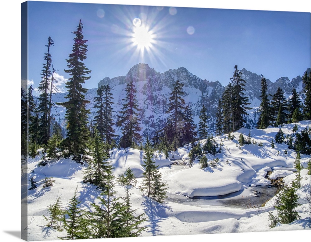 USA, Washington State, Alpine Lakes Wilderness. Frozen alpine pond with fresh snow and Cascade Range.