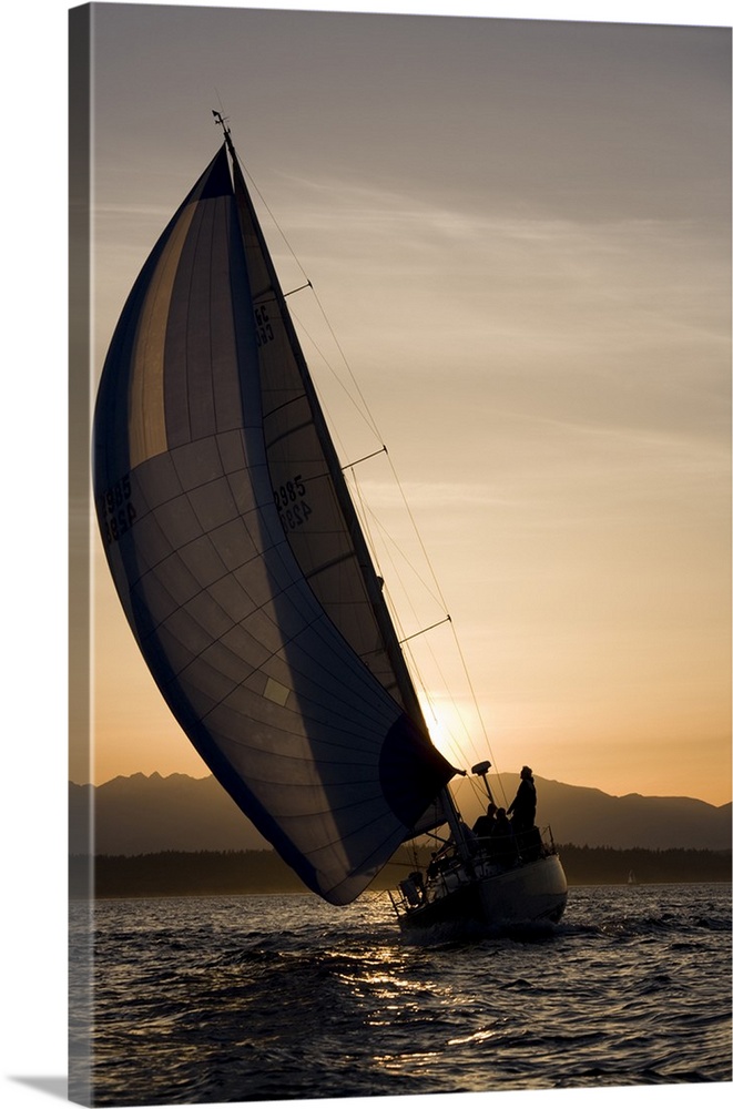 USA, Washington, Seattle, Setting sun lights yacht sailing in Elliot Bay on spring evening.