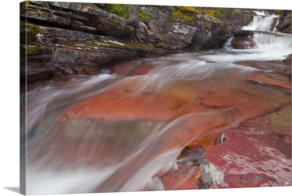 Water cascades down the red rock of Virginia Creek in Glacier National Park, Montana, USA