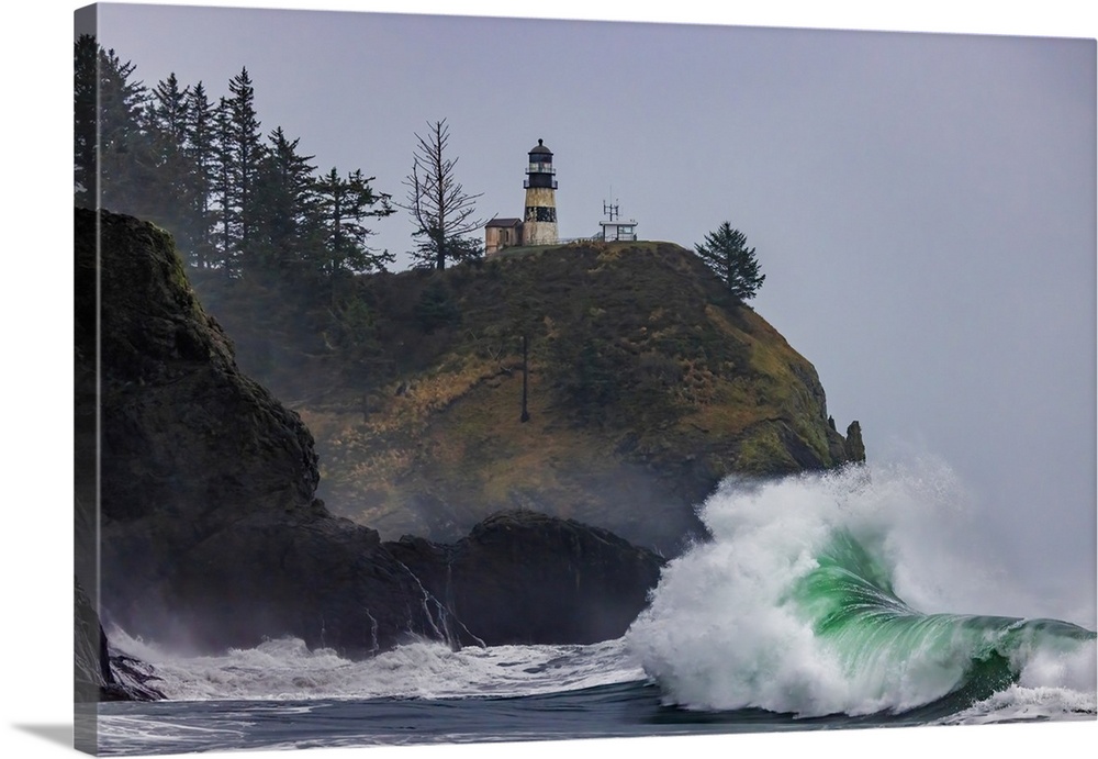 Waves crash below lighthouse at Cape Disappointment State Park, Washington State, USA.