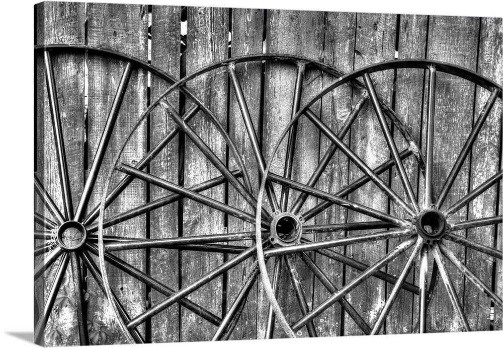 Black and white photo of wooden fence  and old wagon wheels, Middleton Place Plantation, Charleston, South Carolina.