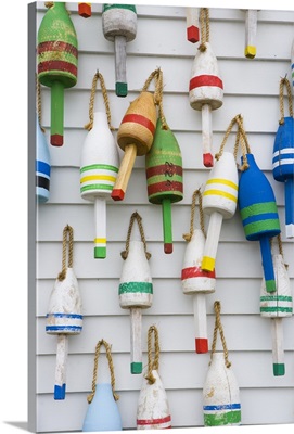 Wooden lobster buoys hang on a wall in Stonington, Maine