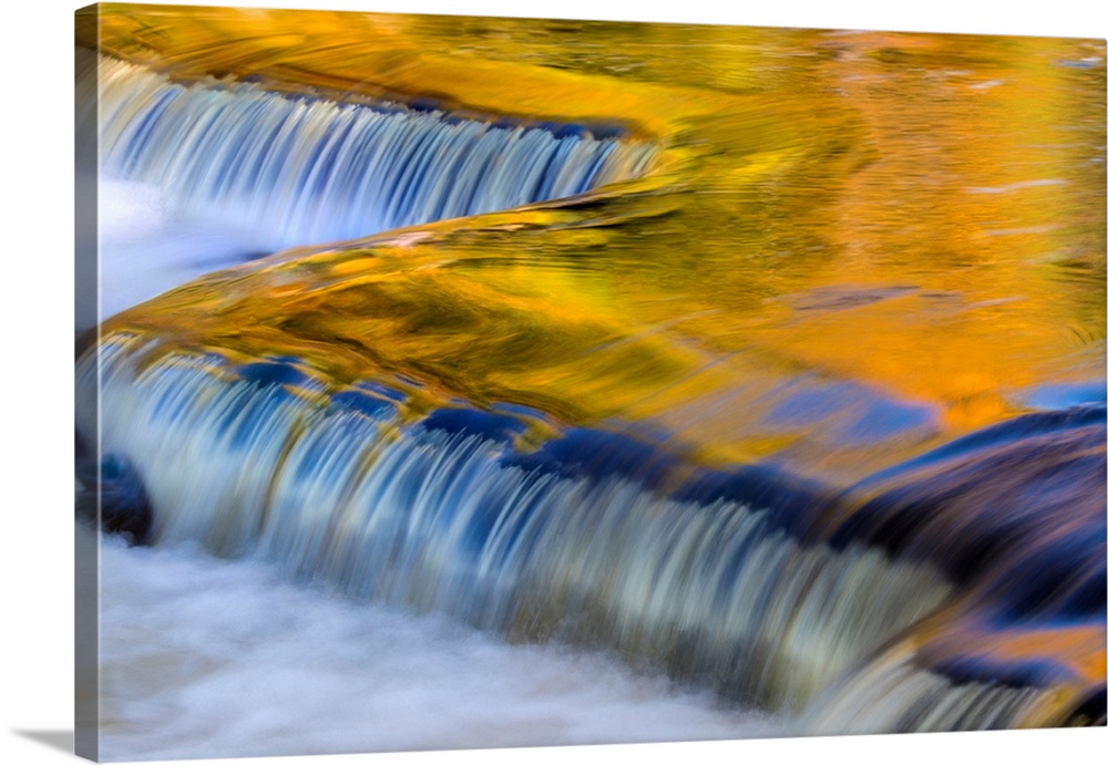 Yellow and golds reflect from tree into The Middle Branch of the Ontonagon River at Bond Falls Scenic Site, Michigan USA