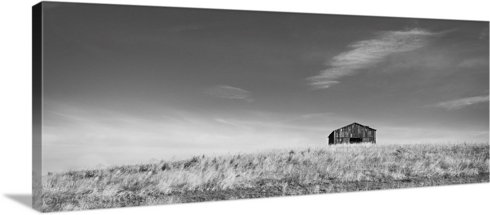 Barn on a hill in black and white.