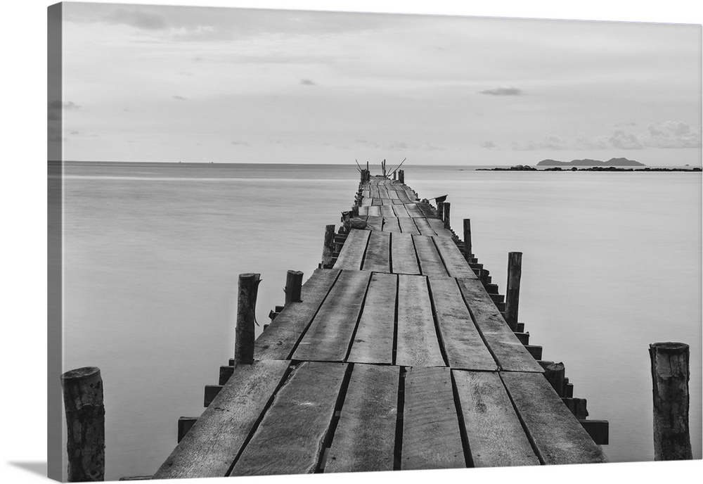 Black and white photograph of a beach wooden pier.